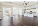 Expansive living room featuring hardwood floors, tray ceilings and an open layout to the kitchen at 9416 Bullfrog Court, Gibsonton, FL 33534