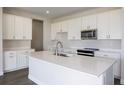 Bright kitchen with white cabinets, stainless steel appliances, and quartz countertops at 9955 Surrey Rose Dr, San Antonio, FL 33576
