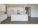 Spacious kitchen with white cabinetry, stainless steel appliances and an island sink at 9955 Surrey Rose Dr, San Antonio, FL 33576