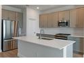 Modern kitchen featuring stainless steel appliances, ample storage, and a center island at 9989 Surrey Rose Dr, San Antonio, FL 33576