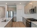 Beautiful kitchen features stainless steel appliances, quartz countertops, and wood-look flooring at 9989 Surrey Rose Dr, San Antonio, FL 33576