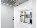 A view of the kitchen with modern stainless steel appliances and grey tile backsplash and light grey cabinets at 14130 Rosemary Ln # 3215, Largo, FL 33774