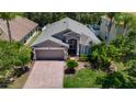 Inviting single-Gathering home featuring a brick driveway, mature landscaping, and a well-manicured lawn at 16219 Nottingham Park Way, Tampa, FL 33647