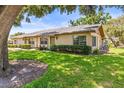 Charming one-story home with well-maintained landscaping, green lawn, and a mature tree at 1908 Canterbury Ln # 28, Sun City Center, FL 33573