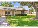 Charming one-story home with well-maintained landscaping, green lawn, and walkway at 1908 Canterbury Ln # 28, Sun City Center, FL 33573