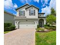 Charming two-story home with a brick paver driveway and lush green lawn at 19200 Roseate Dr, Lutz, FL 33558