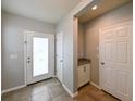 Inviting foyer featuring tile flooring, a storage closet, and a convenient drop zone at 19200 Roseate Dr, Lutz, FL 33558