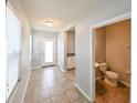 Bright foyer with tile flooring, leading to a powder room and other living spaces at 19200 Roseate Dr, Lutz, FL 33558
