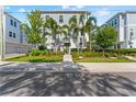 Charming townhome featuring lush landscaping, palm trees, and a fenced front yard at 202 S Tampania Ave # 3, Tampa, FL 33609
