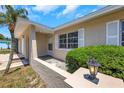 Inviting front porch with decorative stone accents, a charming light fixture, and manicured landscaping at 204 Cove Ct, Clearwater, FL 33756