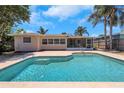Backyard view featuring a private in-ground pool and a screened-in patio area at 204 Cove Ct, Clearwater, FL 33756
