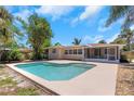 Backyard view of a refreshing in-ground pool with a spacious concrete deck at 204 Cove Ct, Clearwater, FL 33756