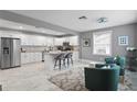 Bright, open kitchen with stainless steel appliances, an island, and an adjacent living area at 2933 W Alline Ave, Tampa, FL 33611