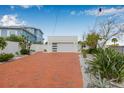 A modern garage with brick driveway and well-maintained landscaping for enhanced curb appeal at 321 N Boulevard Of The Presidents, Sarasota, FL 34236