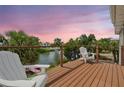 Waterfront deck offers serene views of the water, palm trees and tropical landscaping at 3227 Rose Arbor Dr, Hernando Beach, FL 34607