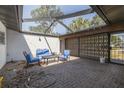 Covered brick patio with comfortable seating and a decorative screen, perfect for relaxing and entertaining outdoors at 328 Tallahassee Ne Dr, St Petersburg, FL 33702