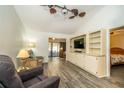 Bright and airy living room featuring a vaulted ceiling, built-in shelving, and sliding glass doors at 35145 Whispering Oaks Blvd, Dade City, FL 33523
