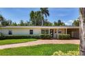 Charming single-story home featuring a brick driveway, lush landscaping, and a welcoming covered entrance at 4291 Neptune Se Dr, St Petersburg, FL 33705