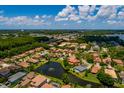 Expansive aerial view of a neighborhood with houses surrounding a lake and mature trees at 4611 Grand Preserve Pl, Palm Harbor, FL 34684