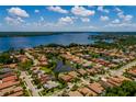 Stunning aerial view of a waterfront home featuring lush landscaping and community lake access at 4611 Grand Preserve Pl, Palm Harbor, FL 34684