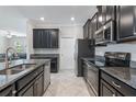 Well-lit kitchen boasts sleek, dark cabinetry, granite countertops and stainless steel appliances at 4690 Coachford Dr, Wesley Chapel, FL 33543