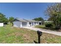 A single-story home featuring a well-maintained lawn and convenient attached garage and driveway at 5341 Tangerine Dr, Zephyrhills, FL 33542