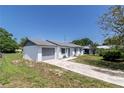This single-story home features a well-maintained lawn and a convenient attached garage at 5341 Tangerine Dr, Zephyrhills, FL 33542