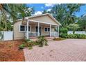 Charming home featuring a covered porch, well-maintained landscaping, and a brick driveway leading to the entrance at 546 26Th N Ave, St Petersburg, FL 33704