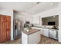 Modern kitchen featuring stainless steel appliances, granite countertops, a central island, and sleek white cabinetry at 7103 Bridgeview Dr, Wesley Chapel, FL 33545