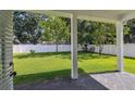 View of the backyard featuring a well-manicured lawn, trees, and a privacy fence at 807 W Kentucky Ave, Tampa, FL 33603
