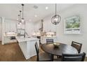 Modern kitchen with white cabinetry, stainless steel appliances, a center island, and a dining area at 807 W Kentucky Ave, Tampa, FL 33603