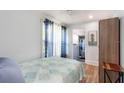 Light-filled bedroom featuring wood floors, a ceiling fan, and stylish window treatments at 945 8Th N St, St Petersburg, FL 33712