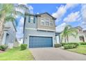 Two-story home featuring an attached two-car garage, with palm trees and manicured landscaping at 1028 Oliveto Verdi Ct, Brandon, FL 33511