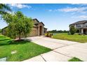 Beautiful home with a spacious driveway, green lawn, and scenic water view in a quiet neighborhood at 11878 Thicket Wood Dr, Riverview, FL 33579