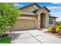 Attractive single-Gathering home with a two-car garage, stone facade, and colorful landscaping at 11878 Thicket Wood Dr, Riverview, FL 33579