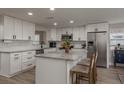 Bright kitchen featuring white cabinetry, stainless steel appliances, and a center island with seating at 11991 104Th Ave, Seminole, FL 33778