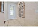 Elegant foyer showcasing decorative tile flooring, an ornate metal wall hanging and a glass paneled front door at 12009 Whistling Wind Dr, Riverview, FL 33569