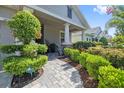 Inviting front porch with stone pathway and decorative landscaping leading to a covered entranceway at 12009 Whistling Wind Dr, Riverview, FL 33569