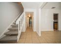 Inviting entryway featuring neutral tile flooring, stairway to the second level and open hallway leading to the back at 12780 N 57Th St, Tampa, FL 33617