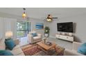 Bright living room featuring a ceiling fan, tile flooring, a large window, and neutral color scheme at 13125 Wilcox Rd # 16202, Largo, FL 33774