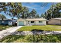 Well-maintained home with a green lawn, light exterior paint, blue garage door and coordinated trim at 1573 Cumberland Ln, Clearwater, FL 33755