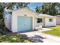 Single story home featuring a light colored brick facade, blue garage door and light-colored coordinated trim at 1573 Cumberland Ln, Clearwater, FL 33755