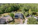 Aerial view of home and pool surrounded by beautiful trees, with a pond nearby at 16014 Amberly Dr, Tampa, FL 33647