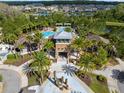 Aerial view of the community pool area with palm trees and lounge area at 1844 Odiorne Point Ln, Wesley Chapel, FL 33543