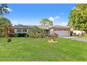 Charming single-story home boasts a lush green lawn, mature trees, and a well-maintained exterior, creating a welcoming facade at 2701 65Th Ave S, St Petersburg, FL 33712