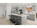 Bright, modern kitchen features gray cabinets, stainless steel appliances, and a spacious island with seating at 2713 Brianholly Dr, Valrico, FL 33596
