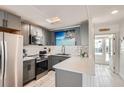 Modern kitchen with gray cabinetry, white subway tile backsplash, and stainless steel appliances at 28 Seaside Ct, Holmes Beach, FL 34217