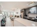 Open-concept living space featuring a modern kitchen with stainless steel appliances and a cozy living area at 28 Seaside Ct, Holmes Beach, FL 34217