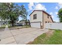 Side view of a two-story home with white exterior, brown trim, and long driveway with basketball hoop at 3104 Apricot St, Seffner, FL 33584