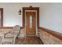 Close-up of an inviting front door with glass detailing, flanked by stone and comfortable seating at 3104 Apricot St, Seffner, FL 33584